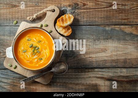 Kürbissuppe mit Croutons und Sahne auf Holztisch. Draufsicht mit Kopierbereich Stockfoto