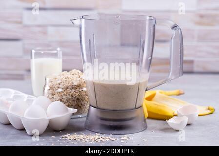 Haferpfannkuchen mit Banane. Schritt für Schritt Kochvorgang. Zutaten Draufsicht. Bananen, Milch, Eier, Hafer, Salz. Holztisch Hintergrund. Speicherplatz kopieren Stockfoto