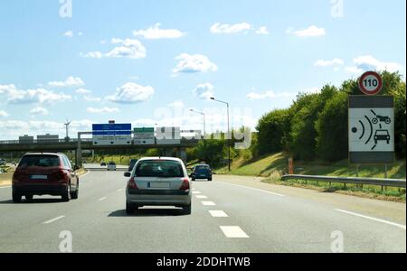 Fahren auf einer Autobahn, mit einem Schild, das eine Radarkontrolle für die Geschwindigkeitsbegrenzung anzeigt. Stockfoto