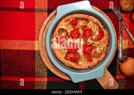 Persimmon und stachelige Birne Feigen di Indica Frucht Herbst Kuchen Mit Süßkäse in runder Backform auf kariertem Textil Stockfoto