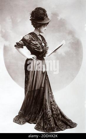 Die bekannte edwardianische englische Bühnenschauspielerin und später silienter Filmstar Kitty Gordon (1878 – 1974) steht und liest, aufgenommen aus einer Fotopostkarte aus dieser Zeit. Stockfoto