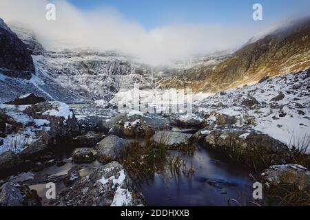 Ein gefrorener Fluss in einer verschneiten Schlucht im Winter Stockfoto
