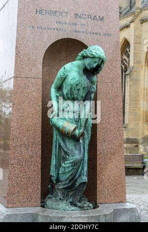 Skulptur einer Frau, die aus einer Vase am Fuße des Herbert Ingram Memorial vor der St. Botolph's Church in Boston, Lincolnshire, Großbritannien, goss. Stockfoto