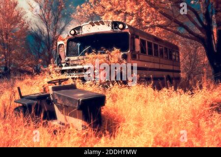 Ein Schulbus und ein Rasenmäher rosten in einem vergessenen Grundstück in Little York, IN. Aufgenommen in 590 nm IR-gefiltertem Licht. Stockfoto