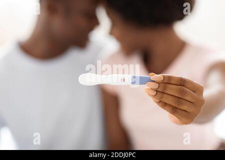 Nahaufnahme eines positiven Schwangerschaftstests in schwarzen Frauenhänden Stockfoto