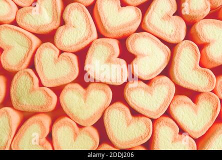 Reihen von Pastell Orange und Gelb Herz geformt Marshmallow Bonbons Für abstrakten Hintergrund Stockfoto