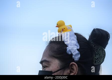 Bangkok, Thailand. November 2020. Eine Protesterin trägt während der Demonstration eine aufblasbare gelbe Ente auf ihrem Kopf.Tausende von prodemokratischen Demonstranten versammelten sich vor dem Hauptsitz der Siam Commercial Bank (SBC), um Thailands König Maha Vajiralongkorn zu fordern, das königliche Vermögen an die Menschen zu übergeben. Die prodemokratischen Demonstranten fordern auch den Rücktritt des thailändischen Premierministers und die Reform der Monarchie. Kredit: SOPA Images Limited/Alamy Live Nachrichten Stockfoto