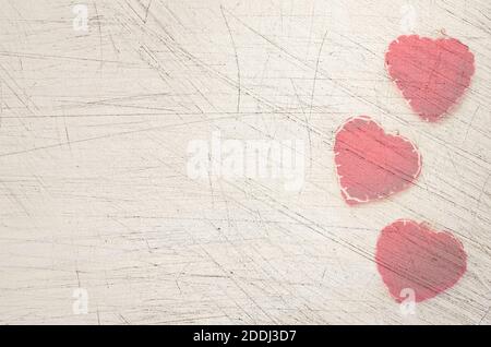 Eine Draufsicht Nahaufnahme eines rosa genähten Herzen auf Ein strukturierter, weiß getönter, dunkler Steinhintergrund Stockfoto