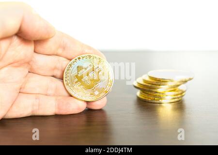 Nahaufnahme einer Hand, die eine Bitcoin hält Stockfoto