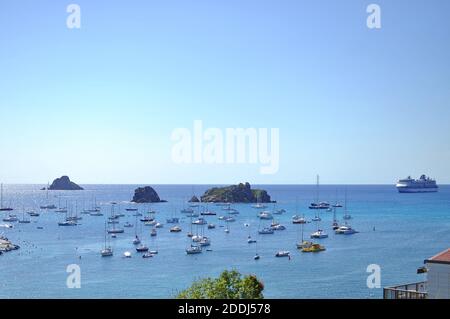 Luftaufnahme von Corossol, erhöhter Blick auf die Küste bei Gustavia, mit verankerten kleinen Booten und Yachten und Celebrity Summit Kreuzfahrtschiff im Hintergrund. Stockfoto