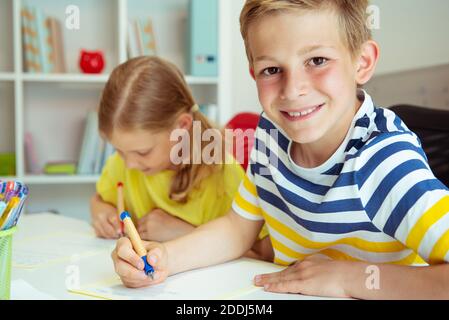 Cute Schulkinder sind kam zurück in die Schule und Lernen in der Tabelle im Klassenzimmer Stockfoto