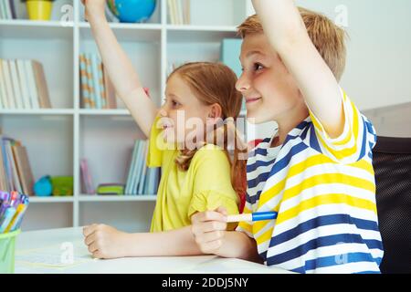 Cute Schulkinder sind kam zurück in die Schule und Lernen in der Tabelle im Klassenzimmer Stockfoto