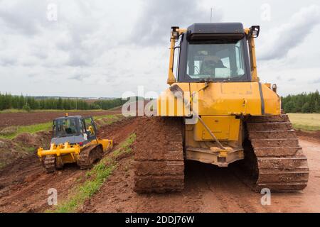 Spezielle Straßenfahrzeuge. Planierraupe Maschine während Baustraßenarbeiten Stockfoto