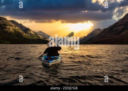 Abenteuerlicher Mann Kajakfahren in Glacier Lake Stockfoto