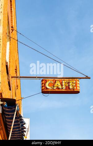 Vintage hängendes Metall-Café-Schild mit Neonbeleuchtung. Stockfoto