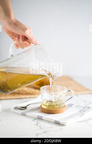 Heißer grüner Tee in einer Tasse und Teekanne auf dem Weißer Hintergrund Stockfoto