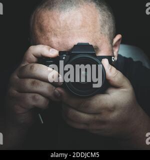 Porträt eines Mannes mit Kamera, Fotograf oder Paparazzi oder Privatdetektiv. Stockfoto