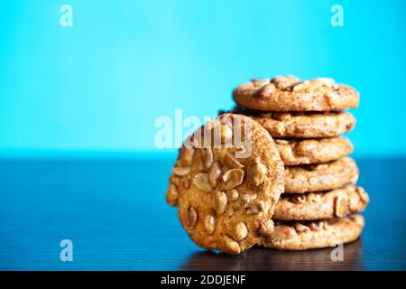 Stapel von Haferflocken Cookies mit Erdnüssen auf blauem Hintergrund Stockfoto