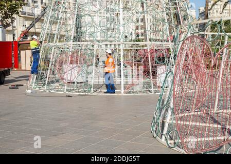 Valencia, Valencia, Spanien. November 2020. Arbeiter, die den Weihnachtsbaum zusammenbauen. Jede autonome Gemeinschaft in Spanien muss neue Anti-Covid-Maßnahmen für die Weihnachtstage verabschieden. Nach der letzten Woche der Rückgang der Infektionen, Valencia beginnt, seine besondere Weihnachten vorzubereiten. Montage des Weihnachtsbaumes und des Kunsthandwerksmarktes auf dem Rathausplatz, Valencia, 25. November 2020. Quelle: Xisco Navarro/ZUMA Wire/Alamy Live News Stockfoto