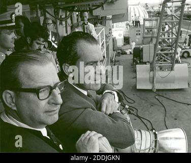 An Bord der USS Hornet - (FILE)--United States President Richard M. Nixon und Dr. Thomas O. Paine, NASA-Administrator sehen Sie Apollo 11 Astronauten Neil A. Armstrong, Michael Collins und Buzz Aldrin Jr., 24. Juli 1969 aus dem Recovery-Hubschrauber für die Mobile-Quarantäne-Station an Bord der USS Hornet begehbar. Der Präsident gratulierte später die Astronauten von Mikrofon, durch ein Fenster des Anhängers Quarantäne spricht. Während der achttägigen Weltraummission Armstrong und Aldrin erkundet die Mondoberfläche und Gesteinsproben für Wissenschaftler studieren zurückgebracht. Collins pilotiert das Befehl modul Stockfoto