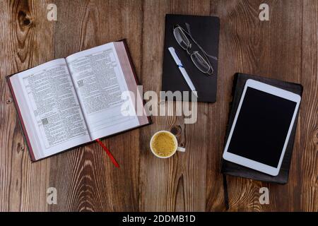 Los Angeles CA US 01 JULY 2020: Heilige Bibel öffnen Morgenlesungen auf einer Tischplatte das digitale Tablet mit einer Tasse Kaffee Stockfoto