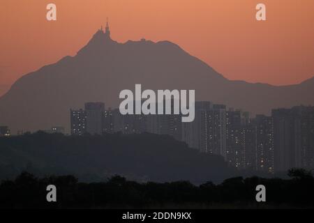 Castle Peak (Tuen Mun) bei Sonnenuntergang, vom Mai Po Nature Reserve, New Territories, Hong Kong 12 Nov 2020 Tin Shui Wai Hochhaus Wohnblöcke in der Mitte Stockfoto