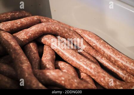 Nahaufnahme der Rohwurst in den Därmen, die in einer Wanne ruhen Stockfoto