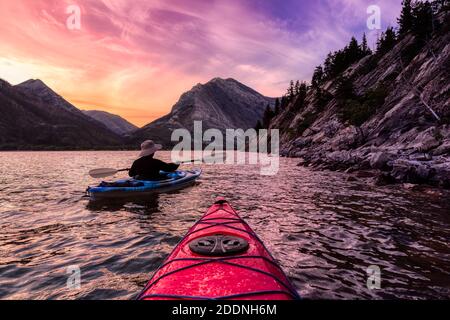 Abenteuerlicher Mann Kajakfahren in Glacier Lake Stockfoto