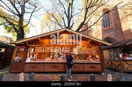 23. November 2020, Niedersachsen, Lüneburg: Eine Frau steht an einem Süßwarenstand in der Altstadt. Foto: Philipp Schulze/dpa Stockfoto