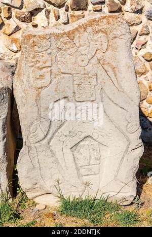 Geschnitzte menschliche Figur in einer steinernen Stele der Danzantes (Tänzer) in der Zapotec-Stätte von Monte Alban, Oaxaca, Mexiko. Stockfoto