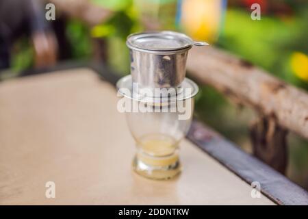 Kaffee tropft im vietnamesischen Stil auf hölzernen Tisch Stockfoto