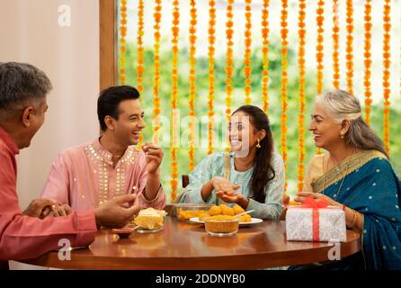 Happy Family sitzt am Esstisch während Diwali Feiern Stockfoto