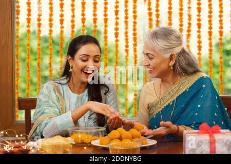 Schwiegermutter Lehre Tochter im Gesetz, wie man macht Ladoo aus Anlass von Diwali Stockfoto