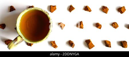 Chaga Pilz und Tasse Tee. Broken Stücke von Birke Baum Chaga Pilz und zum Brauen von natürlichen medizinischen antitumor und antiviralen Detox Tee, Isolati Stockfoto