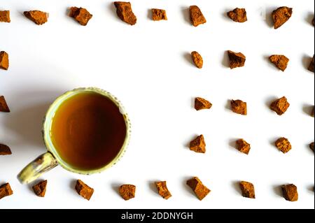 Chaga Pilz und Tasse Tee. Broken Stücke von Birke Baum Chaga Pilz und zum Brauen von natürlichen medizinischen antitumor und antiviralen Detox Tee, Isolati Stockfoto