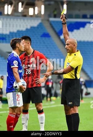 Doha, Katar. November 2020. Der irakische Schiedsrichter Ali Sabah (R) zeigt Ryuta Koike (L) von Yokohama F. Marinos während des Fußballspiels der Gruppe H der AFC Champions League zwischen dem Shanghai SIPG FC und Yokohama F. Marinos in Doha, Katar, 25. November 2020 eine gelbe Karte. Quelle: Nikku/Xinhua/Alamy Live News Stockfoto