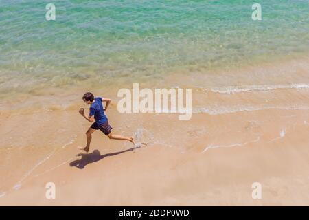 Läufer am Strand am Meer - Blick von oben. Mann Athlet Training Cardio Jogging tun Morgen Training. Hero Luftdrohne Ansicht erschossen, viele Stockfoto