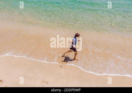 Läufer am Strand am Meer - Blick von oben. Mann Athlet Training Cardio Jogging tun Morgen Training. Hero Luftdrohne Ansicht erschossen, viele Stockfoto