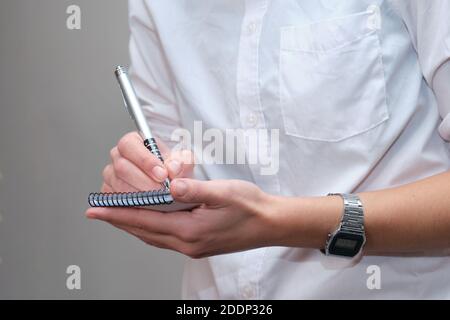 Nicht erkennbare Kellnerin handschriftlich die Aufträge ihrer Kunden. Details zur Bar-Routine. Stockfoto