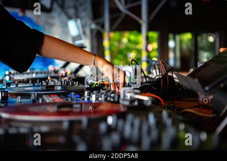 Weibliche dj mischt musikalische Tracks auf Party in bar.Professional Disc Jockey Mädchen spielt Musik auf Hip Hop Unterhaltung Veranstaltung in club.musician regelt V Stockfoto