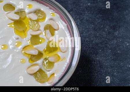 Traditionelles spanisches Gericht, kalte Suppe ajo Blanco oder Ajoblanco aus Knoblauch, Mandeln, Weißweinessig, Olivenöl und grünen Trauben in einer Schüssel, Nahaufnahme, Stockfoto