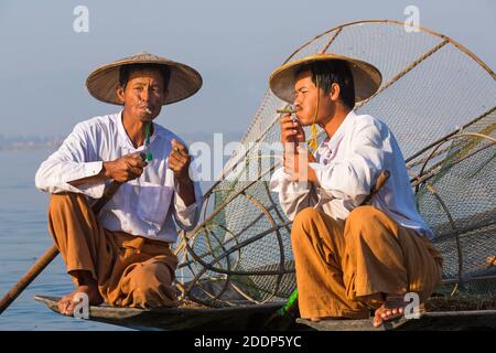 Intha Bein rudern Fischer am Inle Lake, Myanmar (Burma), Asien im Februar - tragen konische Hüte Hut, eine Pause und rauchen, Zigarren rauchen Zigarren Stockfoto