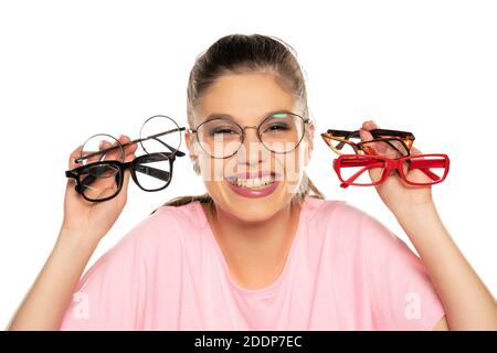 Eine junge Frau wählt einen Rahmen für ihre neue Brille Auf weißem Hintergrund Stockfoto