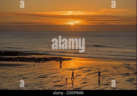 Swansea, Großbritannien. November 2020. Leute gehen am Strand spazieren, während die Sonne über Langland Bay in der Nähe von Swansea an einem kalten und frostigen Herbstmorgen aufgeht. Quelle: Phil Rees/Alamy Live News Stockfoto