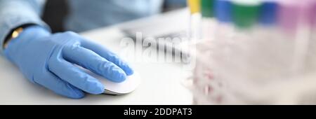 Weibliche Hand in Gummihandschuh hält Computer-Maus in chemischen Nahaufnahme des Labors Stockfoto