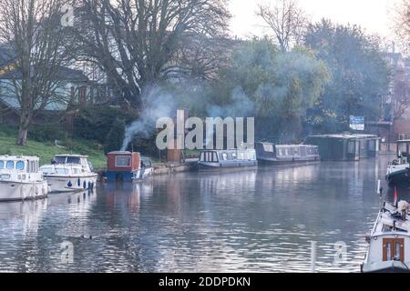 Cambridge, Großbritannien. November 2020. Nebel und Rauch steigen von Hausbooten, die an einem frostigen späten Herbstmorgen auf dem Fluss Cam festmachen. Die Temperaturen fielen über Nacht auf fast den Gefrierpunkt und in den nächsten Tagen wird mehr kaltes Wetter prognostiziert. Kredit: Julian Eales/Alamy Live Nachrichten Stockfoto