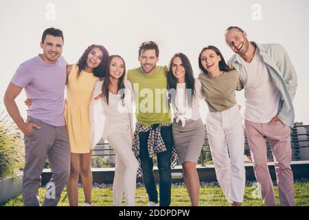 Foto von jungen lächelnd fröhlich positive gute Laune glückliche Gruppe Die Leute umarmen sich gegenseitig und haben Spaß draußen auf dem Dach Stockfoto