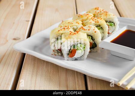 Portion Brötchen mit Lachs, Gurke und Käse in mariniertem Ingwer-Dressing mit goldenem Sesam Stockfoto