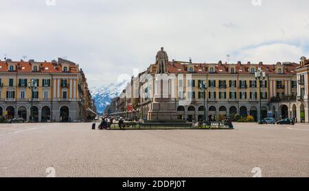 Cuneo, Piemont, Italien 27. März 2010: Piazza Tancredi Duccio Galimberti mit Statue von Giuseppe Barbaroux in Cuneo Italien und Schnee auf den Bergen. Stockfoto