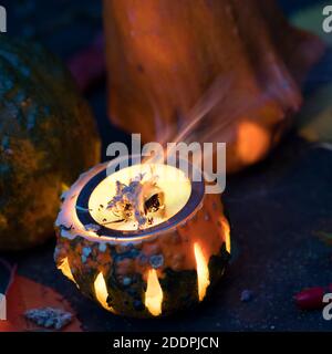 Rauchen mit aromatischen Kräutern in einem Kürbis mit Teelicht, Deutschland Stockfoto